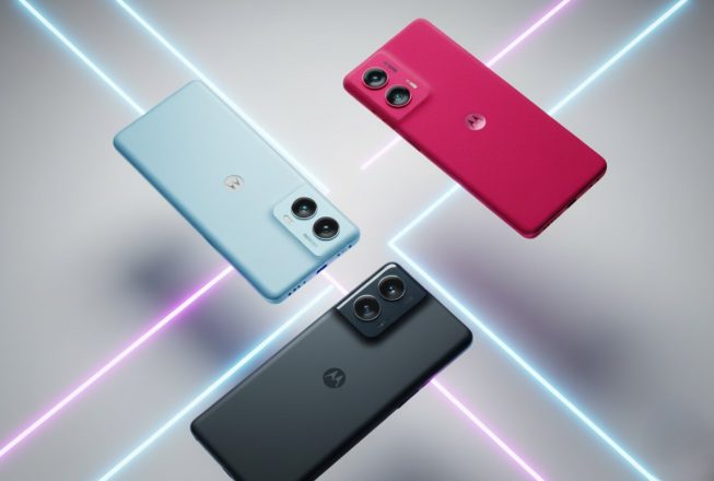 Три смартфони Motorola різного кольору на фоні з неоновими лініями