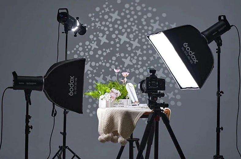 Процес предметної фотозйомки зі студійним світлом Godox та камерою на штативі.